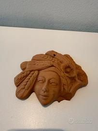 Maschera in terracotta con spighe portafortuna