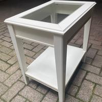 Tavolino in legno con ripiano in vetro.