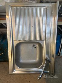 Lavello da cucina in acciaio con rubinetto.