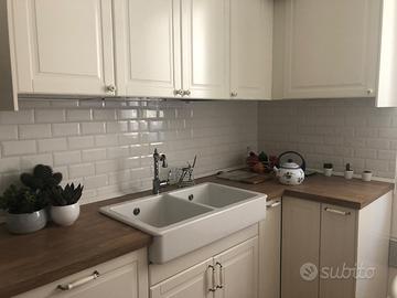 Cucina con elettrodomestici e tavolo.