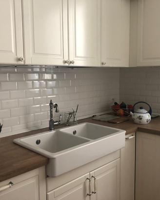 Cucina con elettrodomestici e tavolo.