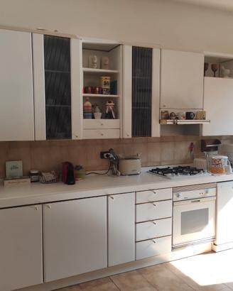 Cucina ad angolo con lavastoviglie e fornetto.