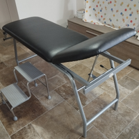 Lettino medico nuovo, sgabello e rotoli di carta