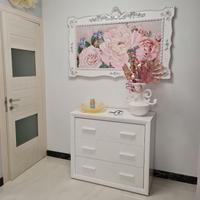 Comò bianco lucido a tre cassetti.