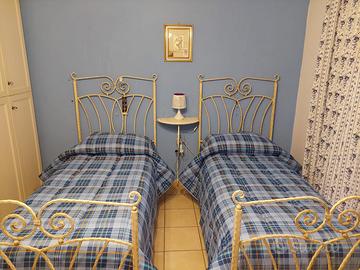 Coppia di letti singoli in ferro battuto +console