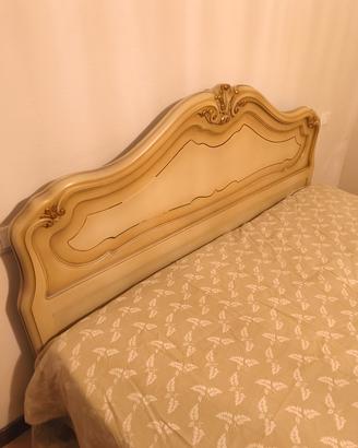letto matrimoniale finemente decorato e comodini 