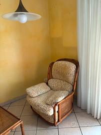 Poltrona in vimini con cuscini a fantasia floreale