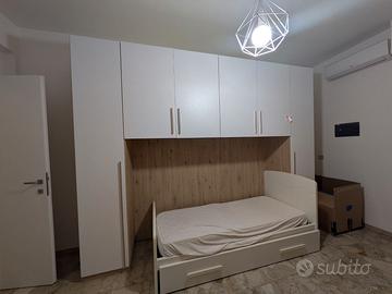 Camera con armadio ponte, letto e comò
