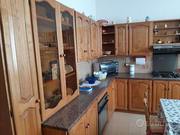 Cucina in legno massello con tavolo e sedie