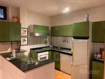 Cucina con piano cottur induzione forno e frigo.