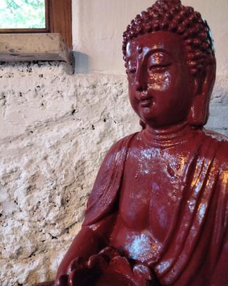 Statua buddha rosso con fiore di loto