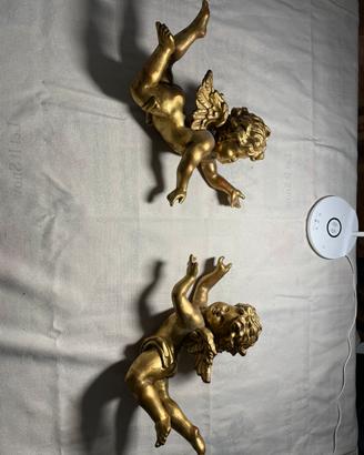 Coppia di antichi putti alati scolpiti in legno