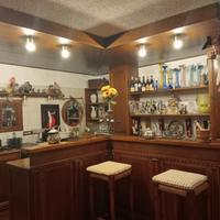 Bar ad angolo con tavolo sedie e panche