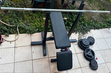 Panca piana con bilanciere e pesi