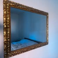 Specchio con cornice dorata .