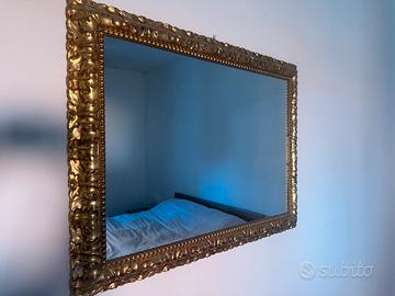 Specchio con cornice dorata .