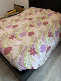 Letto matrimoniale con rete a doghe e cassetti.