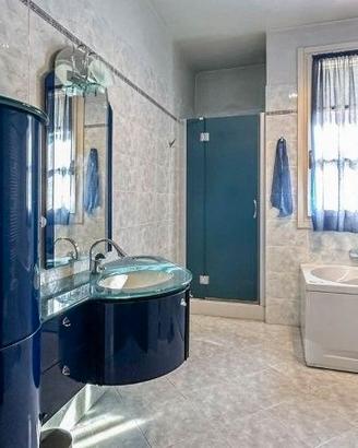 Arredo bagno moderno blu con lavabo in vetro