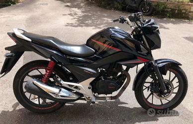 Honda cb 125 con specchietti sportivi e casco shar