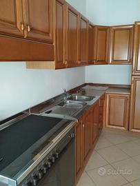 Cucina angolare con credenza e tavolo 