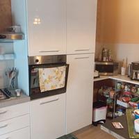 cucina con tavolo, sedie e vetrinetta..