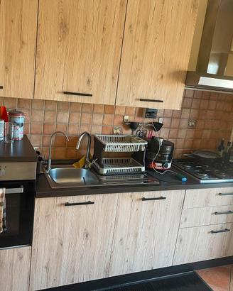 Cucina lineare con elettrodomestici, tav e  sedie.