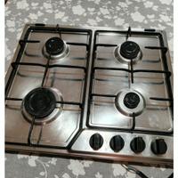 piano cottura, tavolo sedie e parete con mensole 