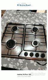 piano cottura, tavolo sedie e parete con mensole 