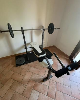 Panca da palestra con bilanciere e dischi