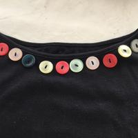 Maglia nera decorata con bottoni