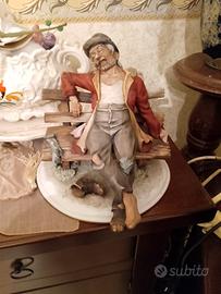 Statua anziano su panchina 