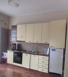 Cucina parete attrezzata e tavolo con sedie