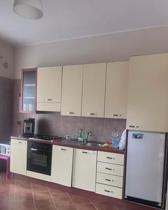 Cucina parete attrezzata e tavolo con sedie