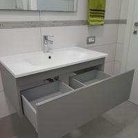 Mobile bagno con lavabo integrato e specchio.