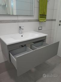 Mobile bagno con lavabo integrato e specchio.