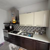 Cucina completa con tavolo e elettrodomestici