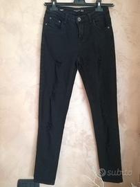 Jeans skinny nero donna con effetto strappato.