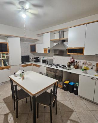 Cucina con elettrodomestici e tavolo