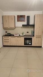 Cucina con frigorifero e piano a induzione