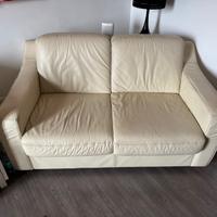 Divano in pelle con puff quadrato.