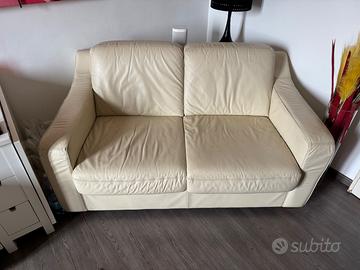 Divano in pelle con puff quadrato.