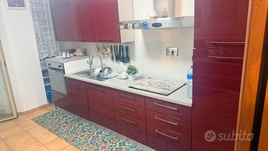 Cucina color bordeaux con credenza extra