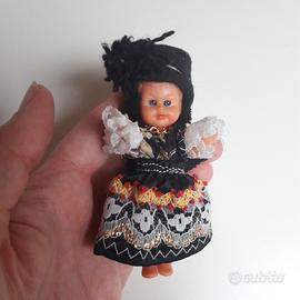 Piccola bambolina con vestito nero decorato