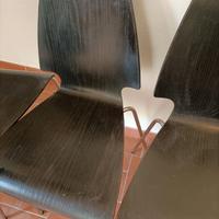 Quattro sedie di legno nere e acciaio