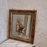 Specchio con bassorilievo e cornice in legno.