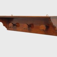 Appendiabiti da parete in legno con ripiano.