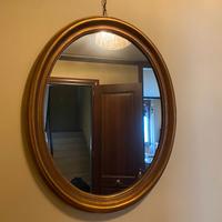 Specchio ovale con cornice in legno dorato