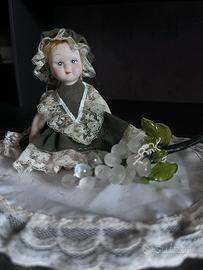 Bambolina in porcellana con vestito verde scuro