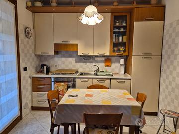 Cucina in linea con tavolo sedie elettrodomestici