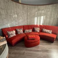 Divano angolare curvo rosso con pouf